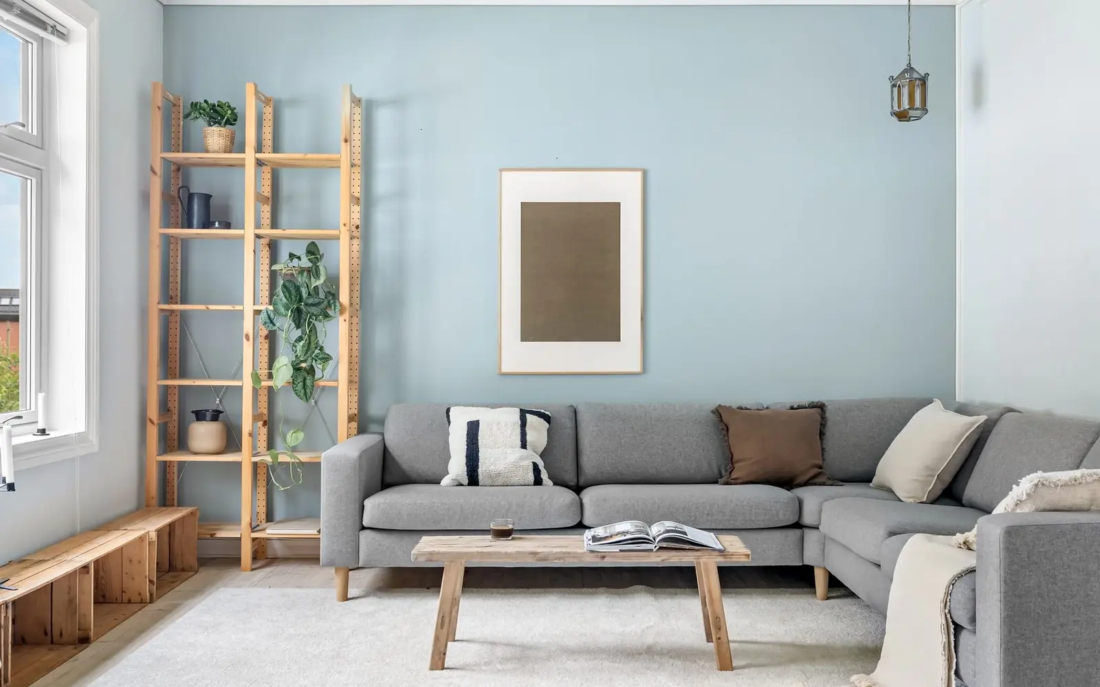 Jasny salon z czystą narożną kanapą i dywanem